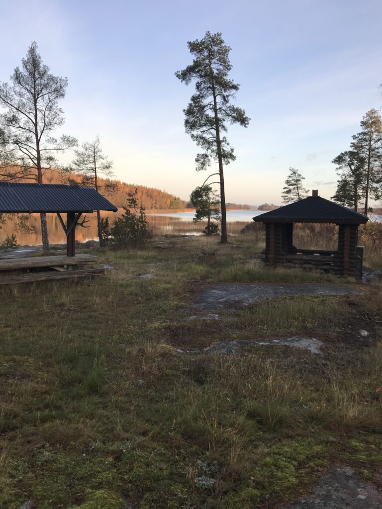 skymnings bild ner mot sjön med grillplats