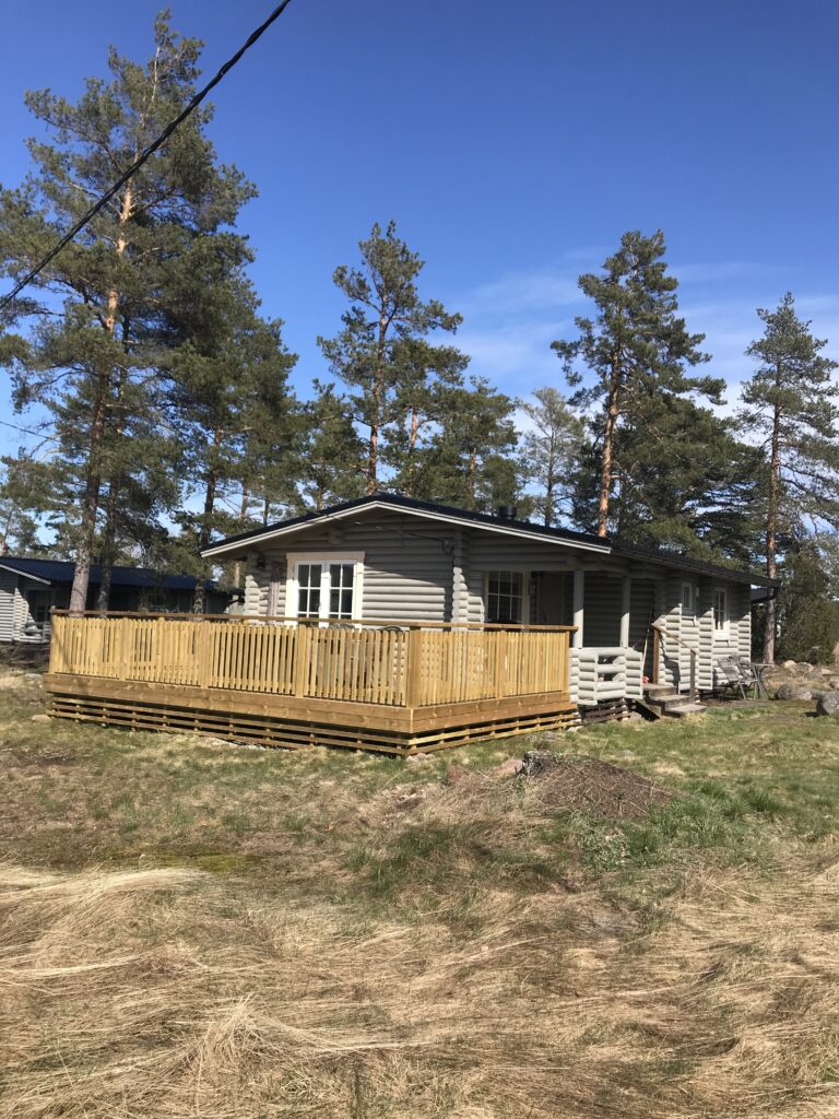 stuga 17 med stor veranda och timrad, grå färg