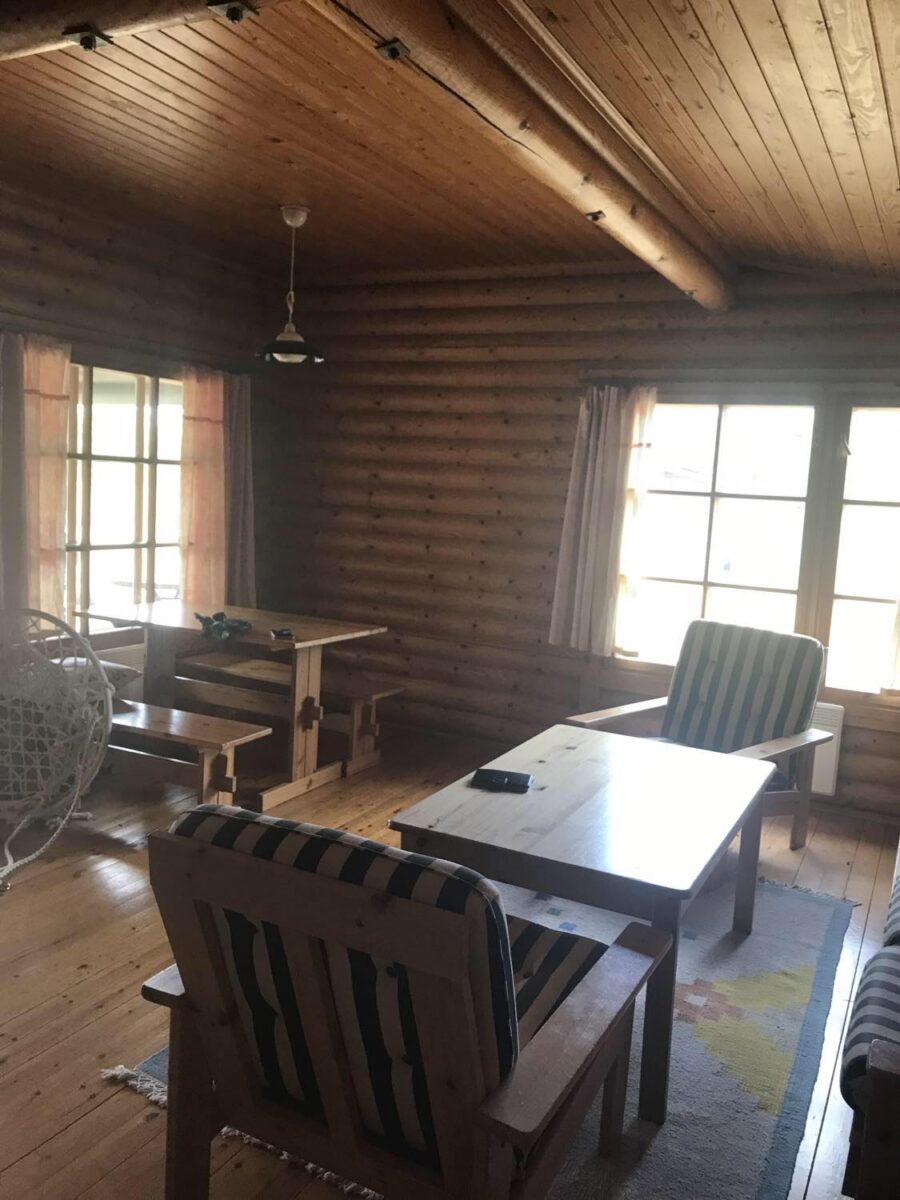 allrum innan renovering, fåtöljer, soffbord , gammalt matbord och två träbänkar allt i furu