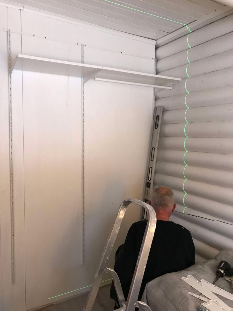 här håller snickaren på att montera plats byggda garderober i sovrummet